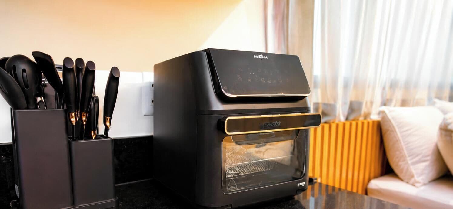 Una cocina con un horno tostador negro, un bloque de cuchillos y un radiador amarillo.