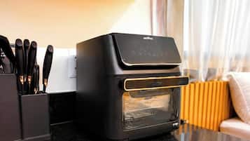 Una cocina con un horno tostador negro, un bloque de cuchillos y un radiador amarillo.