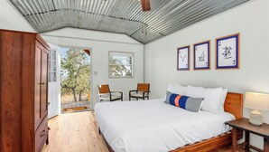 Ein Schlafzimmer mit einem Holzbett, einem Deckenventilator und gerahmten Spielkarten an der Wand.