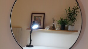 A desk lamp with a light on, a framed picture on a shelf, and potted plants. - De la Mora Hostal (Fernando De La Mora)