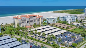 Ein Hotelkomplex mit mehreren Gebäuden, einem Parkplatz und Blick auf den Strand.