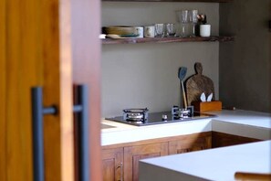 Une cuisine avec des meubles de rangement en bois, un plan de travail et une cuisinière.