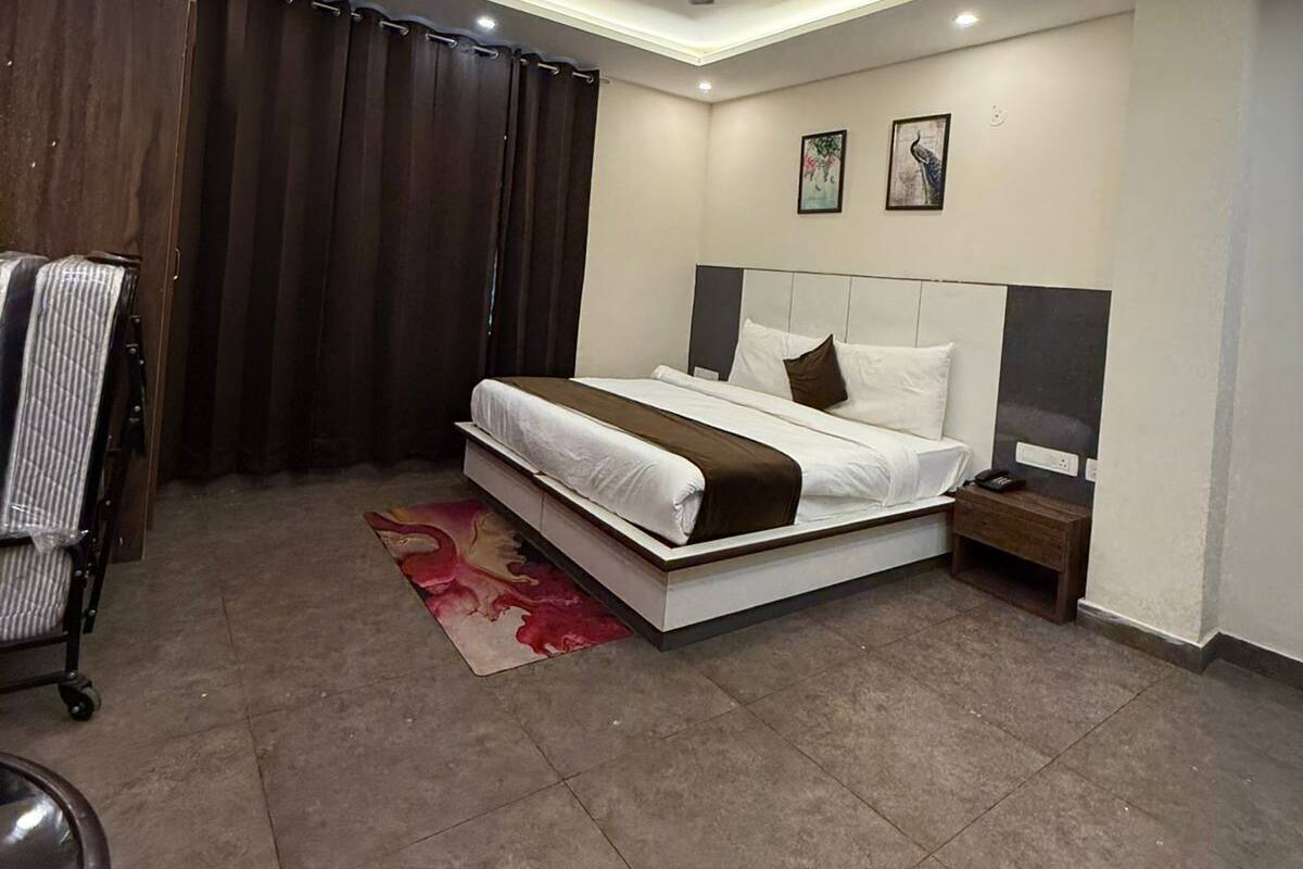 A modern bedroom with a bed, nightstand, and a ceiling fan.