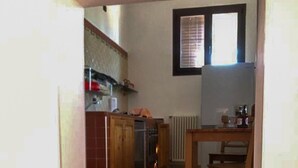 Una cocina con armarios de madera, una estufa y un ventanal.