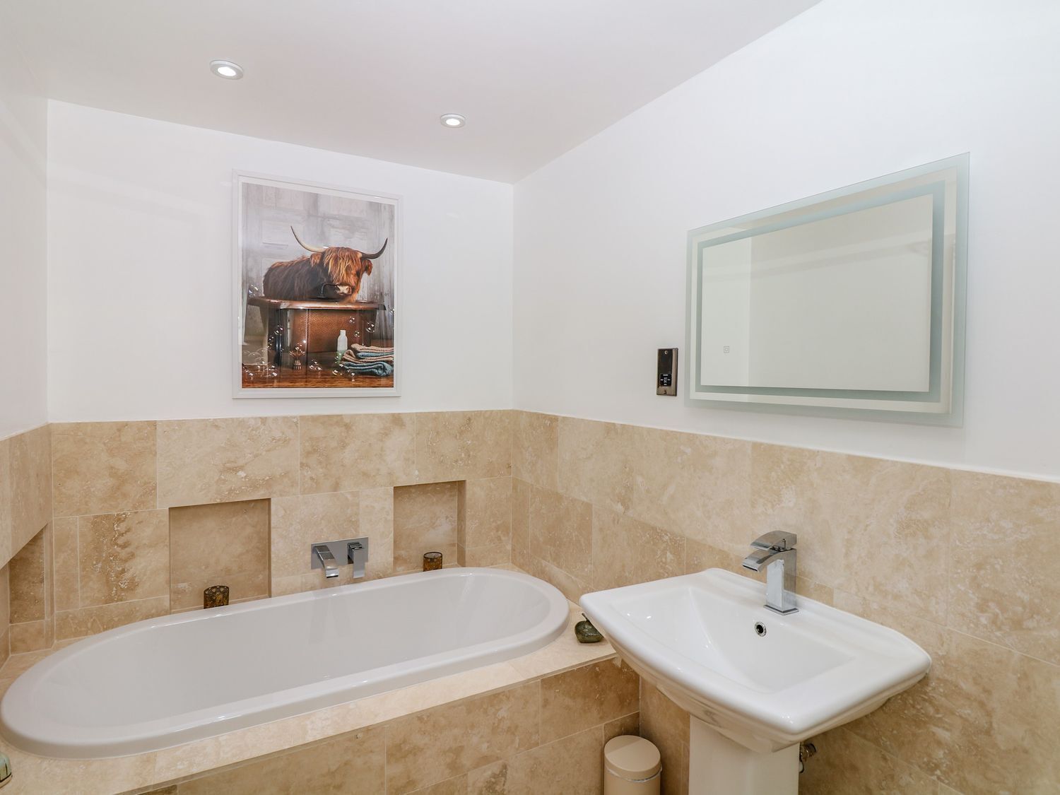 Een moderne badkamer met een badkuip, een wastafel en een spiegel.