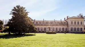 Un grand bâtiment de style classique, doté de fenêtres disposées de manière symétrique et d’une cour intérieure centrale.
