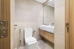 Une salle de bain moderne avec des toilettes, un lavabo et un miroir.