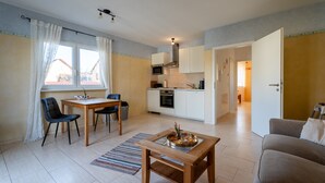 A compact living space with a dining area, kitchen, and a sofa. - Apartment 'Fewo Cannobio' with Balcony and Wi-Fi (Gengenbach)
