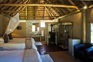 Una habitación con cama, escritorio y zona de ducha.