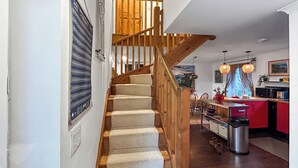Eine Treppe mit Holzwertungen führt zu einem Essbereich mit Aussicht ins Freie.