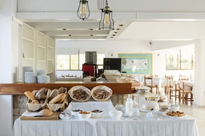 Ein Frühstücksbuffet mit Brot, Gebäck und Milchprodukten.