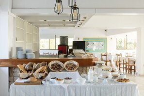 Ein Frühstücksbuffet mit Brot, Gebäck und Milchprodukten.