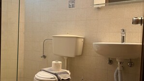 A bathroom with a toilet, a shower, a sink, and a trash bin. - Apartment in A Hotel 'Double Room No 2' with Shared Pool, Wi-Fi and Air Conditioning (Faliraki)