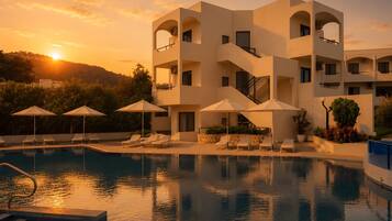 Um hotel moderno com piscina, espreguiçadeiras e guarda-sóis.