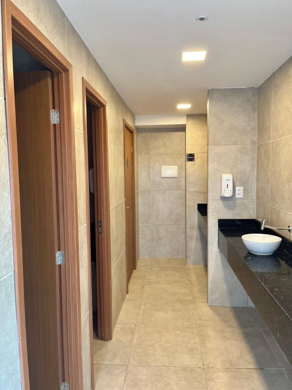 A modern bathroom with a large sink, a mirror, and a towel rack.