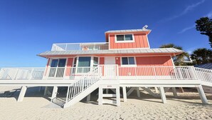 A beach house with a red exterior, white railings, and a balcony. - 3BR Gulf-Front North Captiva Home with Deck (Captiva)
