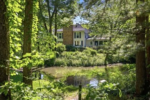 Ein Haus, umgeben von üppigem Grün und einem Teich.