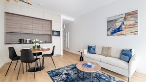 Una sala de estar moderna con sofá, mesa de centro y un comedor con sillas y una mesa.
