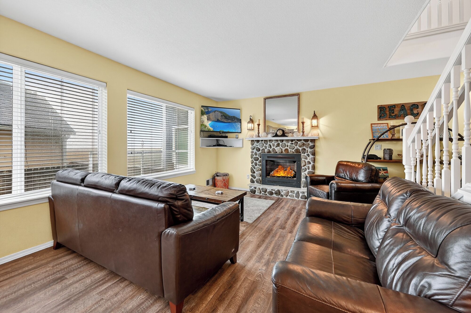 Ein Wohnzimmer mit Kamin, Ledersofas und Fernseher.