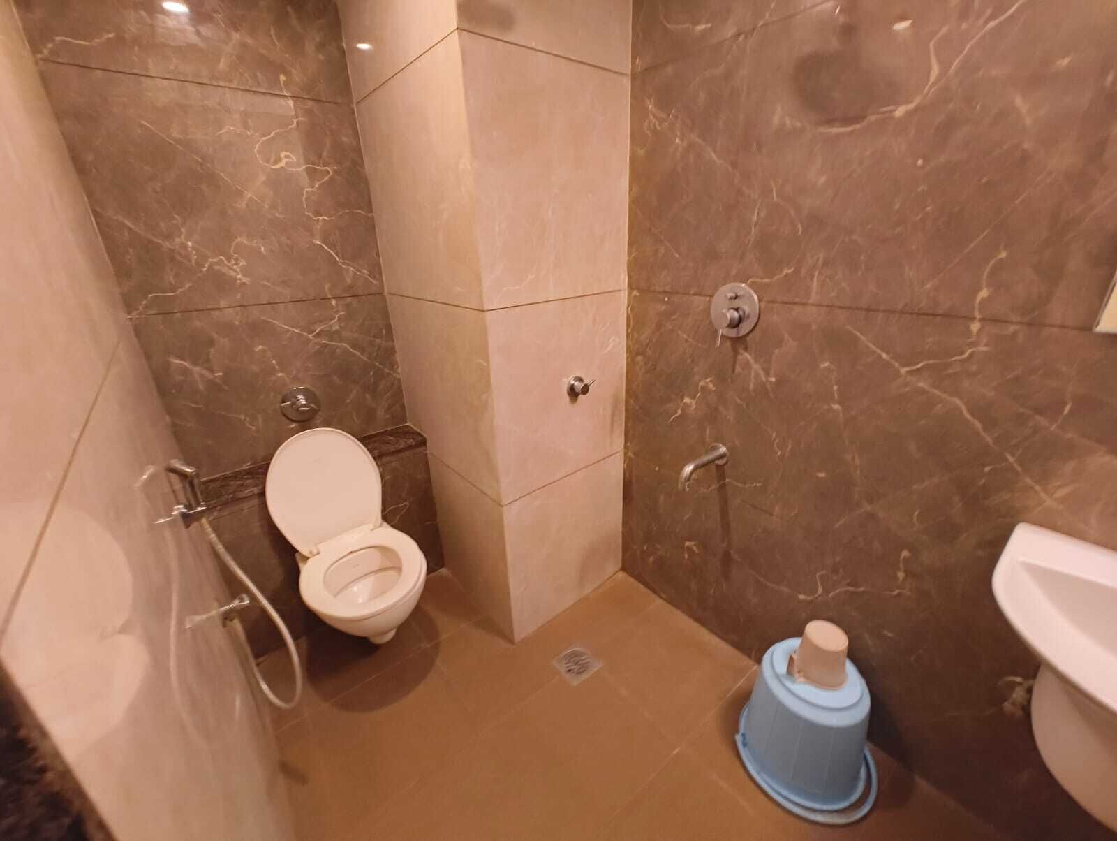 A bathroom with a toilet, a bidet, and a shower area.
