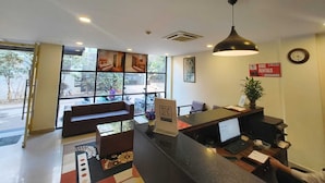 A reception area with a sofa, a desk, a computer, and a bike rental sign. - Apex Inn Manyata (Bengaluru)