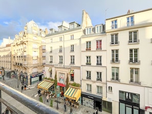 A street view with buildings, outdoor seating, and storefronts. - UrbanFlat 205 - 249 Saint Denis SD1 (París)