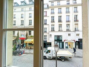 Vista de uma rua com edifícios, um caminhão estacionado e uma bicicleta.