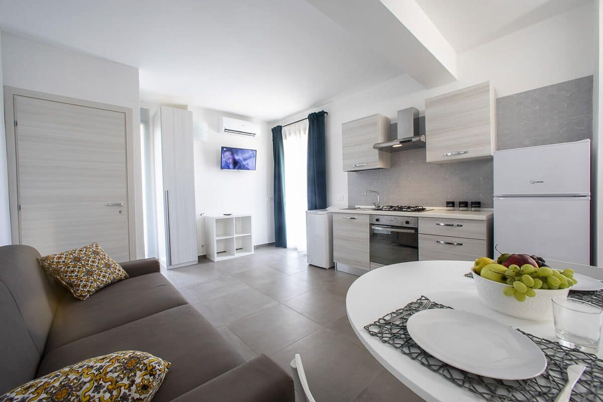 A modern apartment with a living room, kitchenette, and a dining area.
