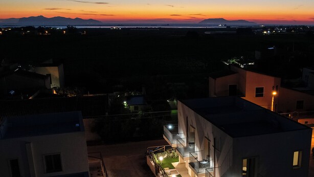 A modern building with multiple balconies and a well-lit outdoor area. - 18 Gradi Apartments (Marsala)