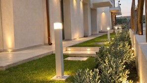 A modern building with a series of balconies, a well-maintained lawn, and a pathway leading to the entrance. - 18 Gradi Apartments (Marsala)