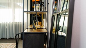 A room with a window, a radiator, a wooden table, and a shelf with decorative items. - Design Apartment 'Fauna by Kamelu' with Private Terrace and Parking (Gengenbach)