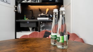 Zwei Flaschen Peterstaler Bier auf einem Holztisch in einer modernen Küche, im Hintergrund ein rotes Sofa.