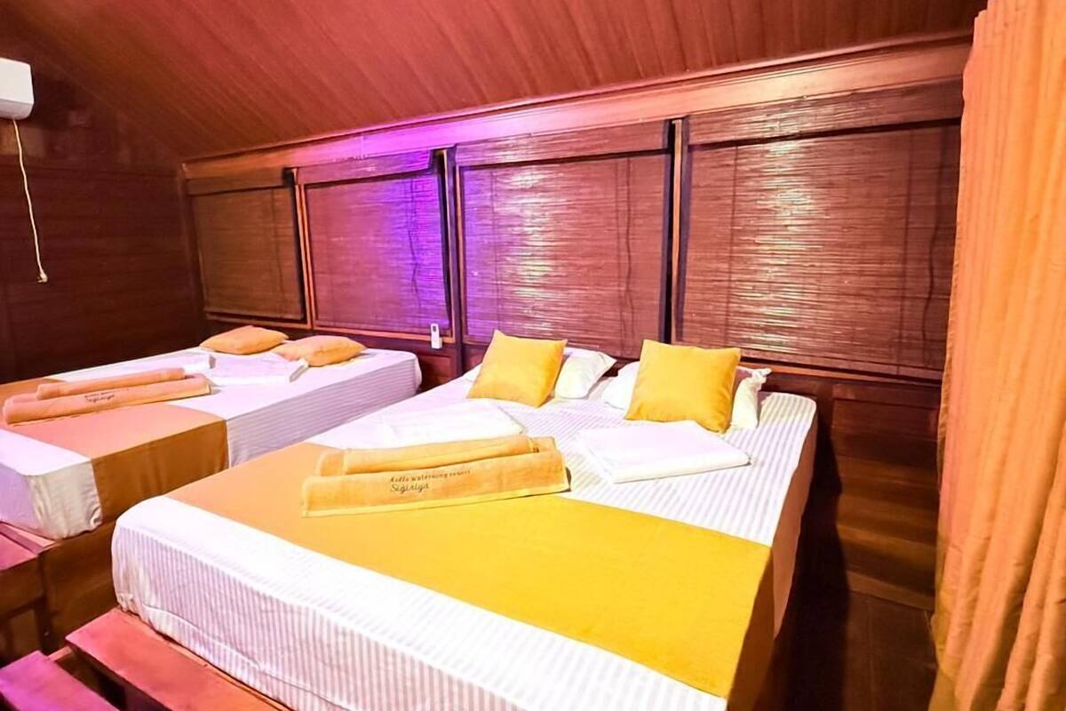 Une chambre avec deux lits, des têtes de lit en bois et un plafond en bois.
