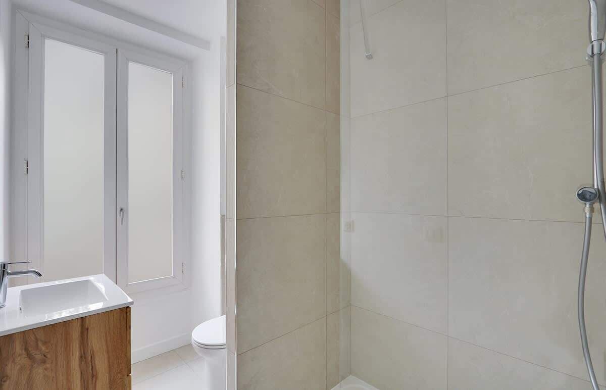 A bathroom with a shower, toilet, and sink.