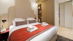 A modern hotel room with a large bed, a wardrobe, and a bedside table. - Oniri - 1-BR with Services - Grand Augustin 1 (Paris)