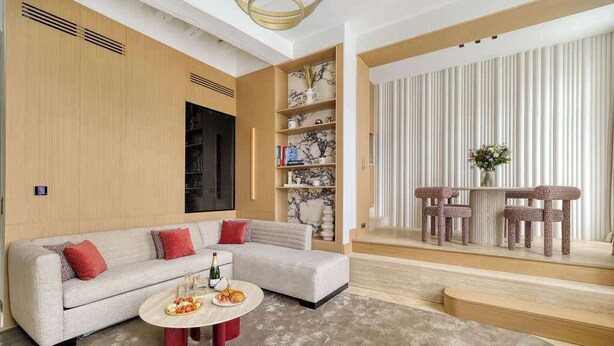 A modern living room with a sectional sofa, a coffee table, and a bookshelf. - Oniri - 1-BR with Services - Grand Augustin 1 (Paris)