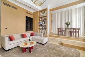 Ein modernes Wohnzimmer mit einem Ecksofa, einem Couchtisch und einem Bücherregal.