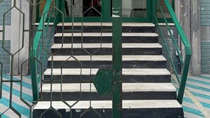 A staircase with green railings leading to an upper level. - Napolitudine (Naples)