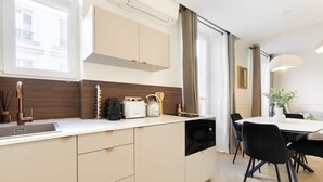 Eine moderne Küche mit Einbauofen, Spüle und Essbereich mit Tisch und Stühlen.