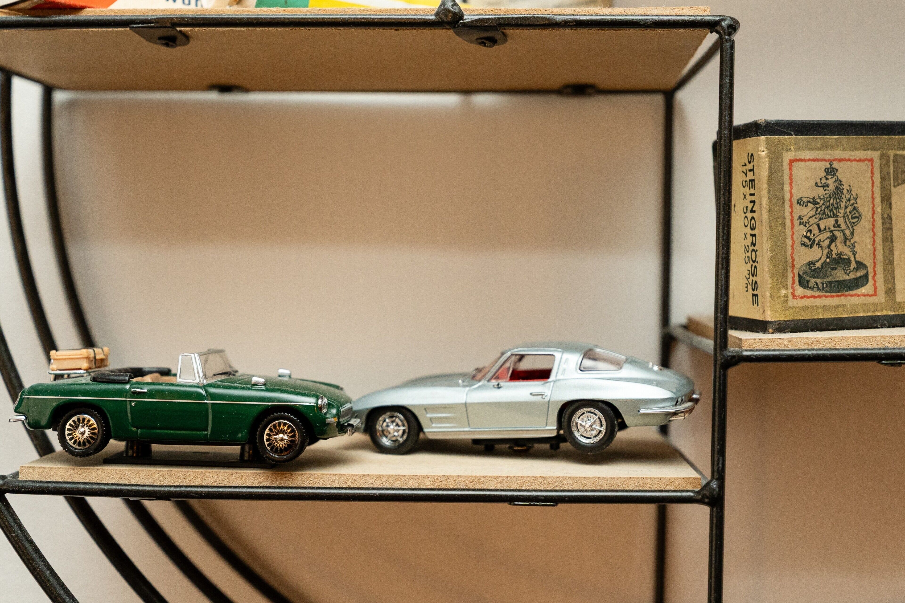 Dos autos a escala en un estante.