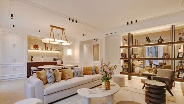 A modern living room with a sofa, coffee table, and armchairs. There is a kitchen area with cabinets and a dining table. - The Lander - 3BR/3BA - Rennes II (Paris)