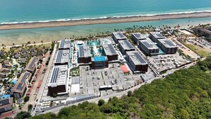 An aerial view of a resort with multiple buildings, a parking lot, and a beach in the background. - Porto Life 2 Luxury Resort by GAV, Porto de Galinhas, Muro Alto Beach, PE (N. São do Ó)
