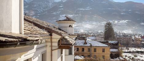 A building with a traditional architectural style, a snow-covered mountain in the background, and a clear sky.