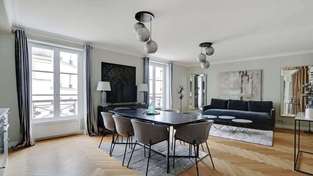 A modern living room with a dining area, large windows, and a black sofa. - A Luxury 3-BR/3BA with A/C in Montmartre (Paris)