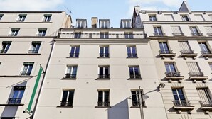 Un immeuble à plusieurs étages, doté d’une façade symétrique, de nombreux balcons et de fenêtres régulièrement espacées.