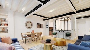 Een moderne woonkamer met een bank, salontafel en een eethoek.