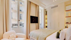 Een hotelkamer met een groot bed, een televisie en een stoel.