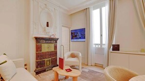 Habitació d'hotel amb una llar de foc, una televisió, un sofà i una cadira.