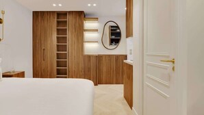 Une chambre à coucher avec un grand lit, une armoire en bois, une échelle, un miroir et une petite table de chevet.