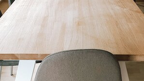 Ein Konferenztisch mit vier Stühlen, einer Lampe und einer weißen Wand.